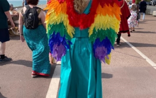 Freethinking fabulous and unique - a lady wearing a long dress and rainbow angel wings